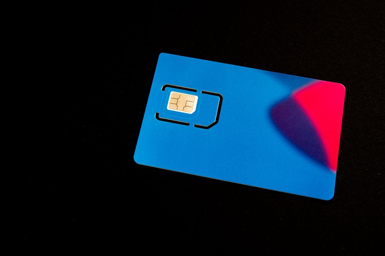 Home A blue SIM card on a dark background with vibrant red and purple accents.